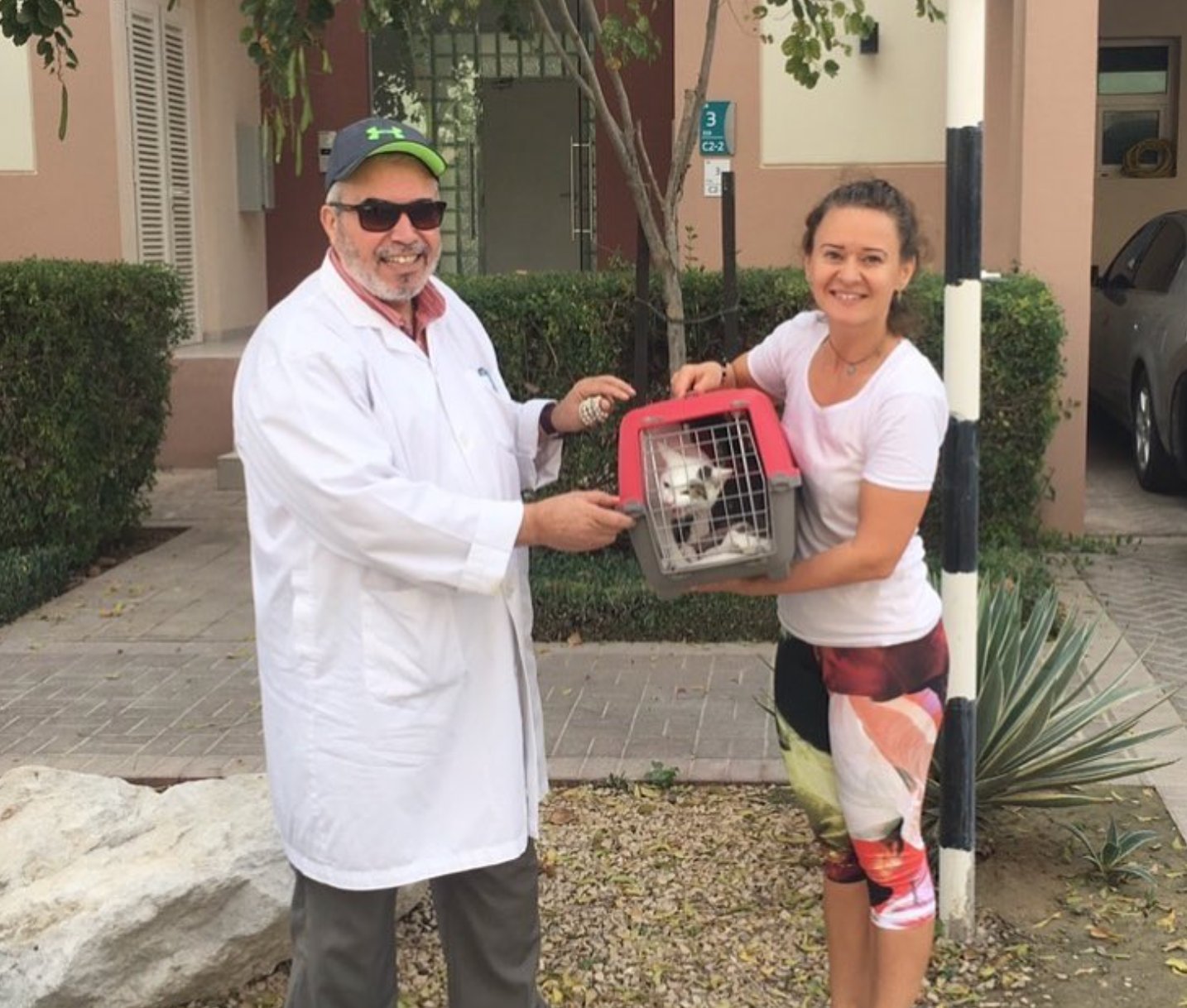 Dr. Faisal handing a cat carrier to a client preparing for international pet travel from Abu Dhabi