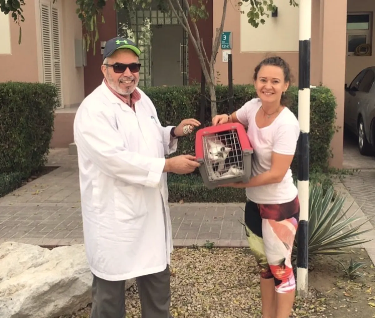 Dr. Faisal handing a cat carrier to a client preparing for international pet travel from Abu Dhabi