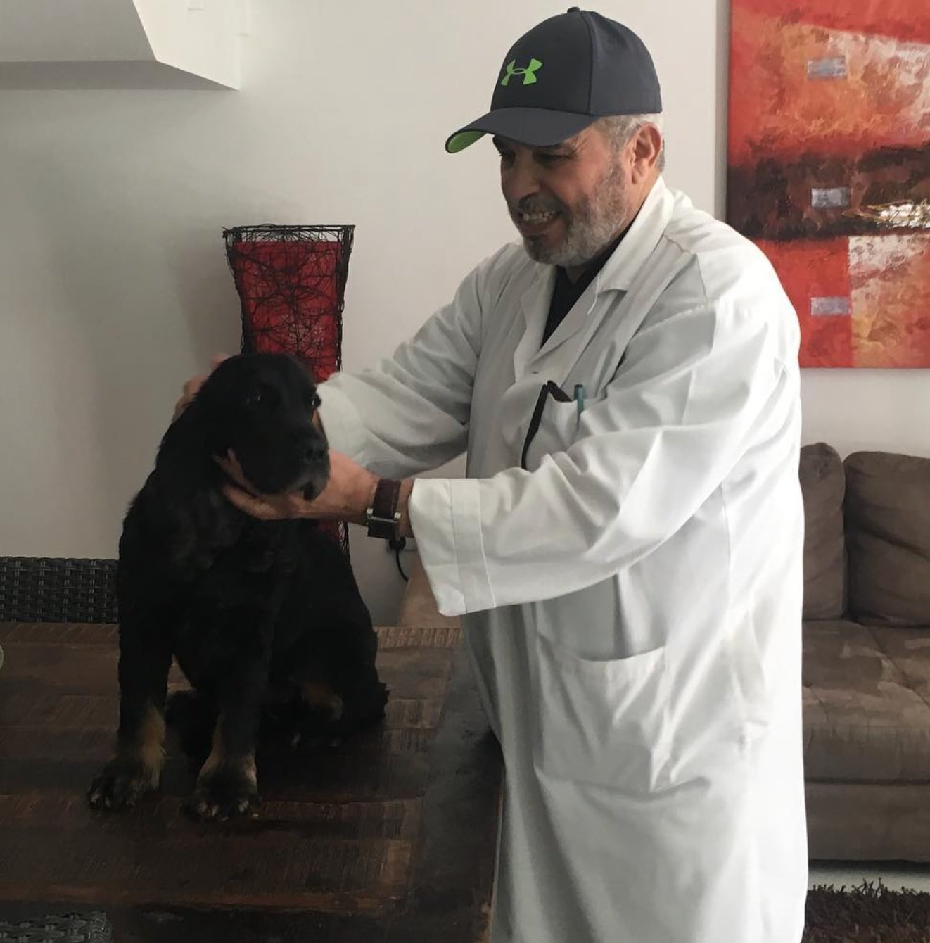 Dr. Faisal Shaheen, founder of New Veterinary Clinic Abu Dhabi, with a young Rottweiler patient