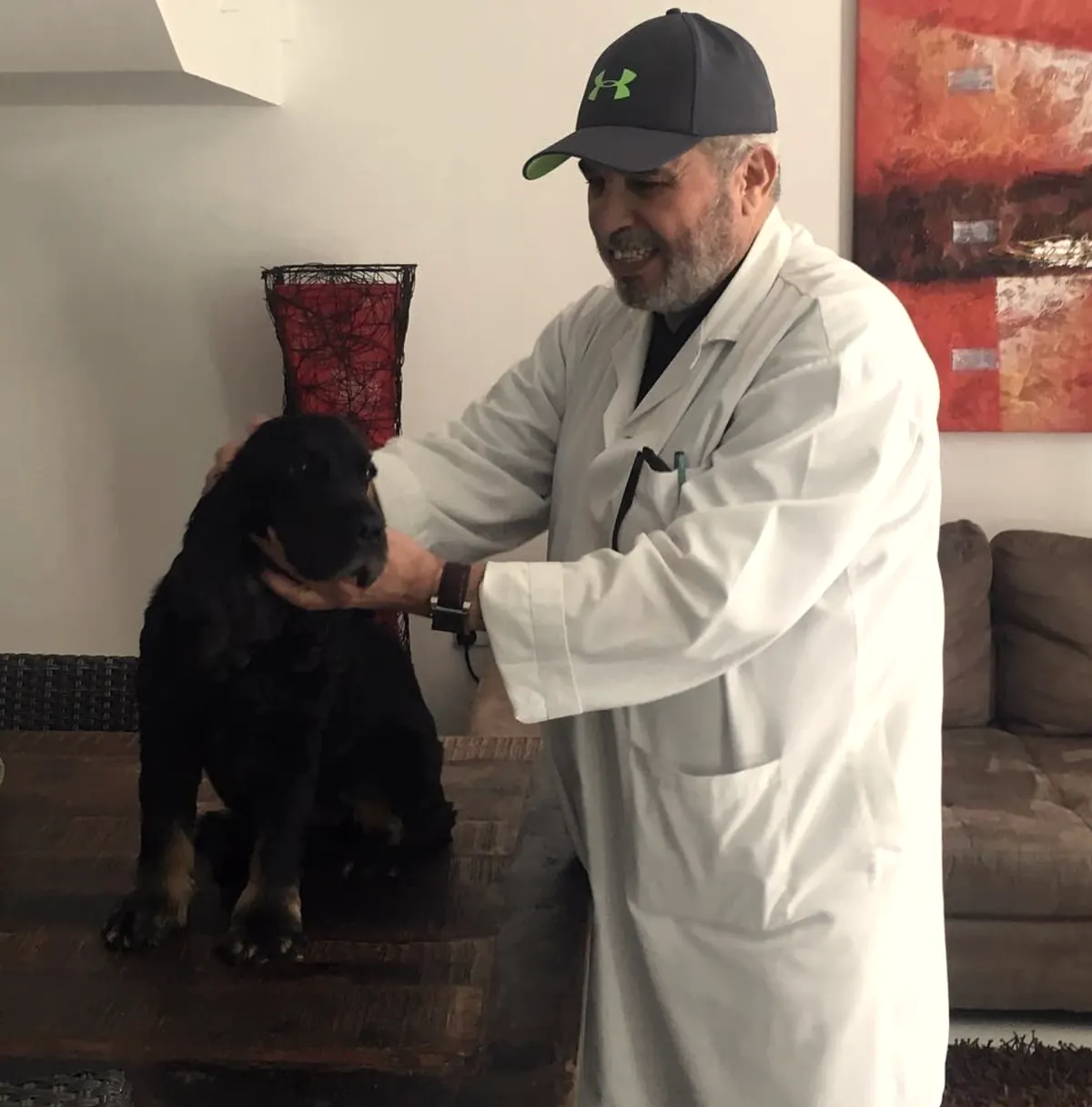 Dr. Faisal Shaheen, founder of New Veterinary Clinic Abu Dhabi, with a young Rottweiler patient